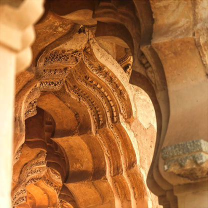 In this abstract fine art photograph, titled "Golden Hour Whispers," we are transported to the enchanting world of the Lotus Mahal. Carved into the very stone that has borne witness to centuries of history, delicate motifs of birds and leaves stand as timeless testaments to the skill and vision of artisans from the past. Their intricacy and artistry mirror the intricacies of life itself.